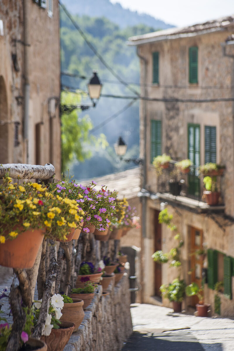 Blumengeschmückte Gasse in Valldemossa mit Natursteinhäusern